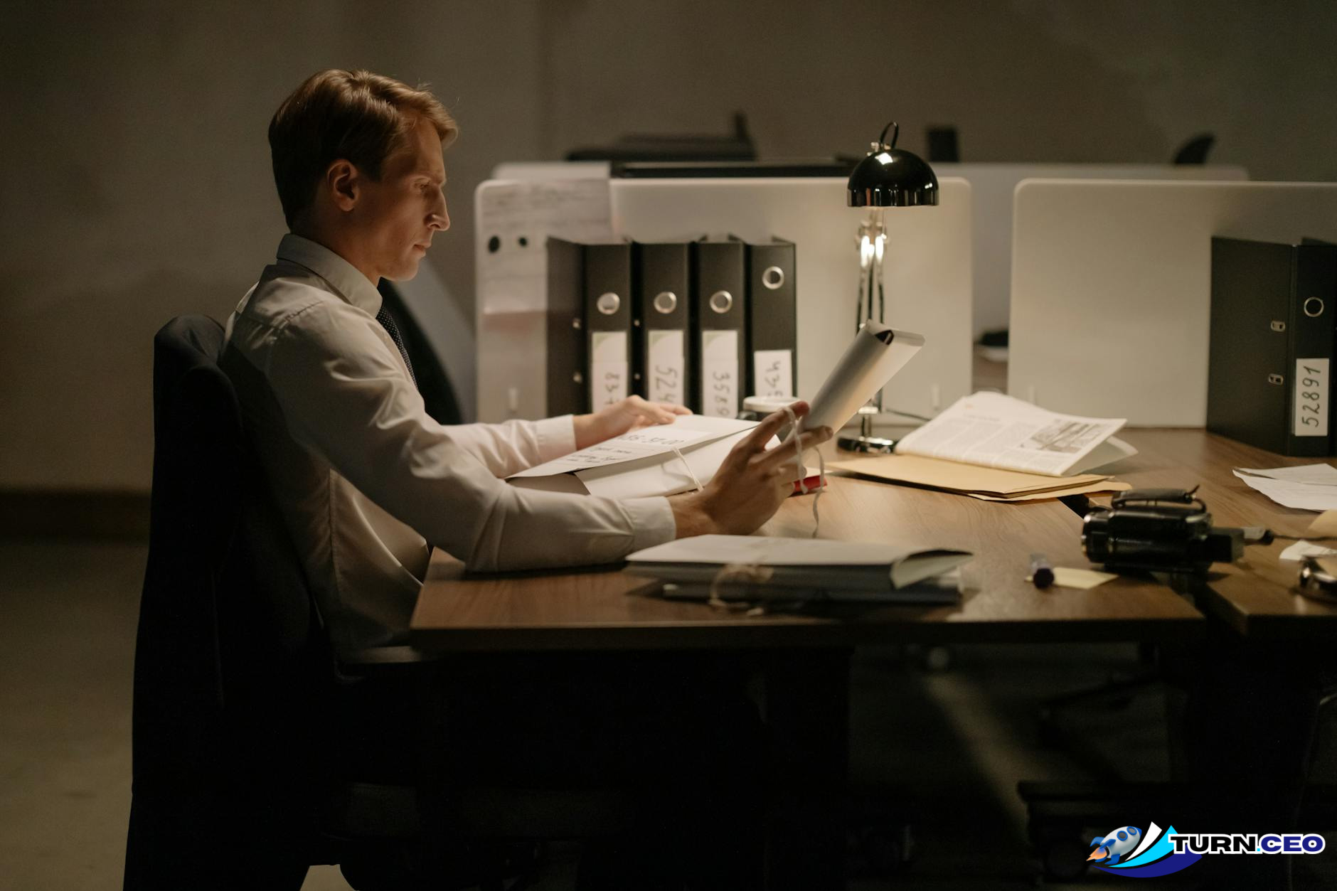 Business owner working late at desk with papers scattered around