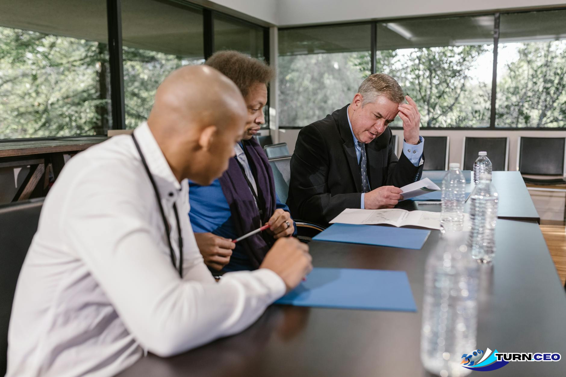 Team meeting around conference table reviewing process documents