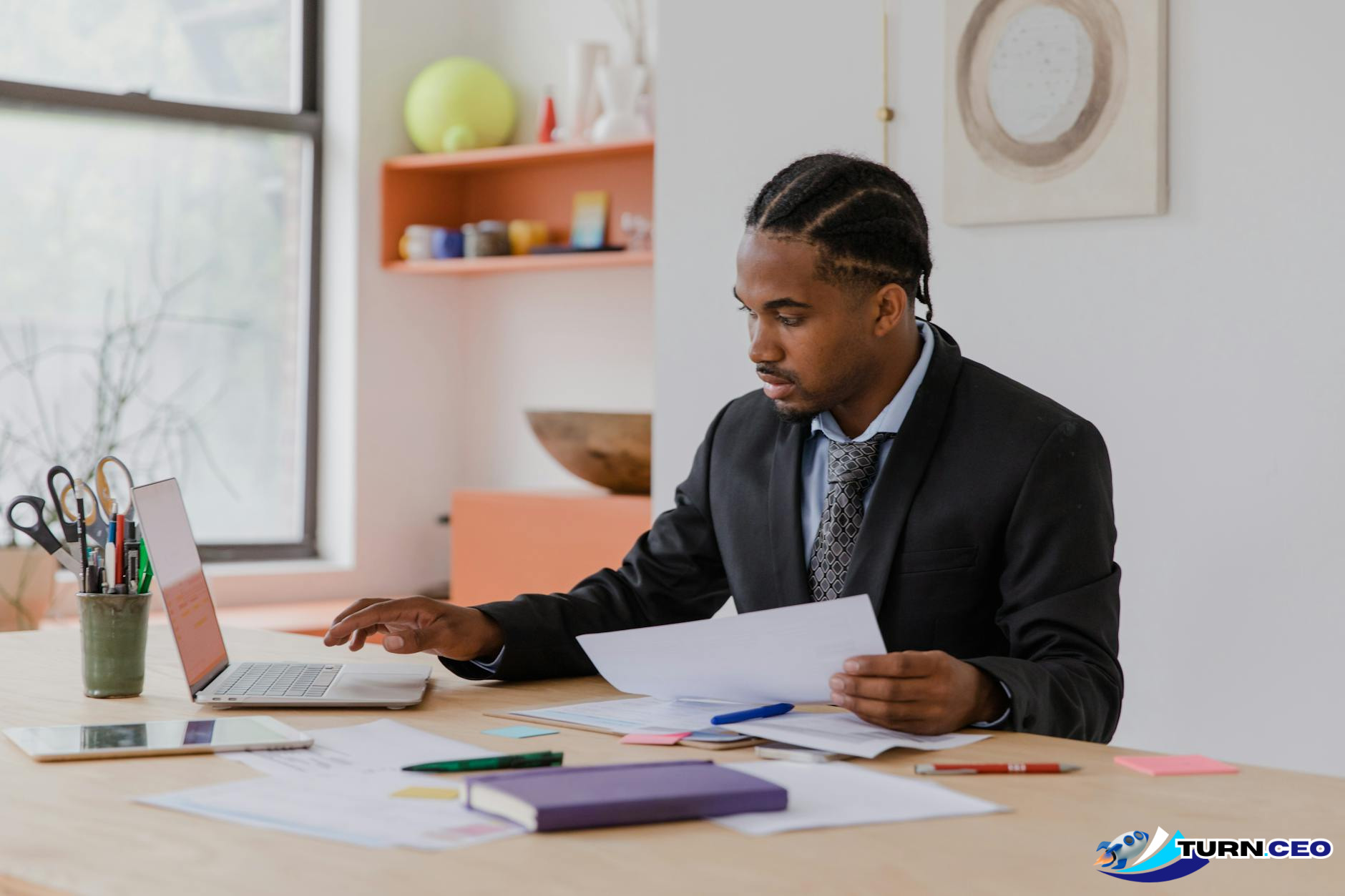 Business executive working alone at desk with laptop and papers