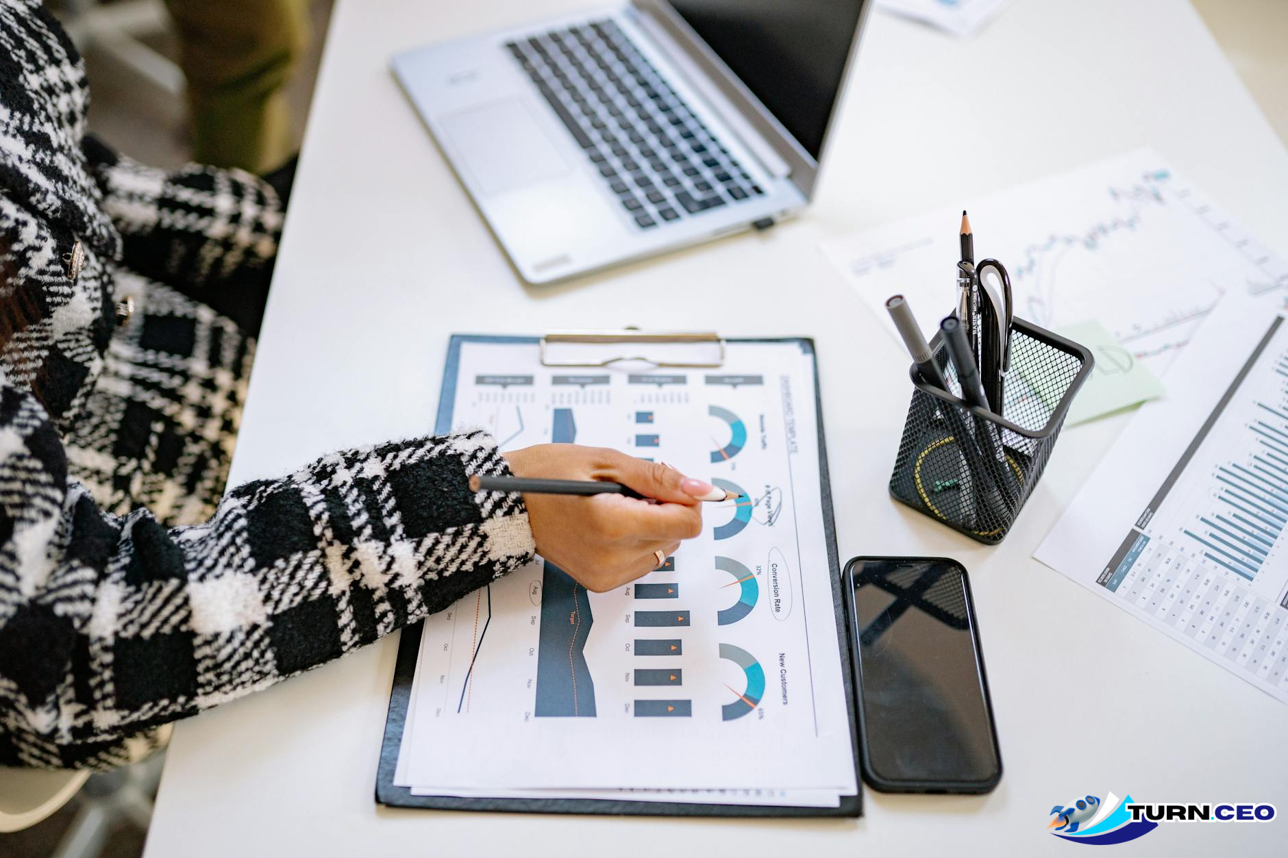 business person reviewing documents and charts at desk