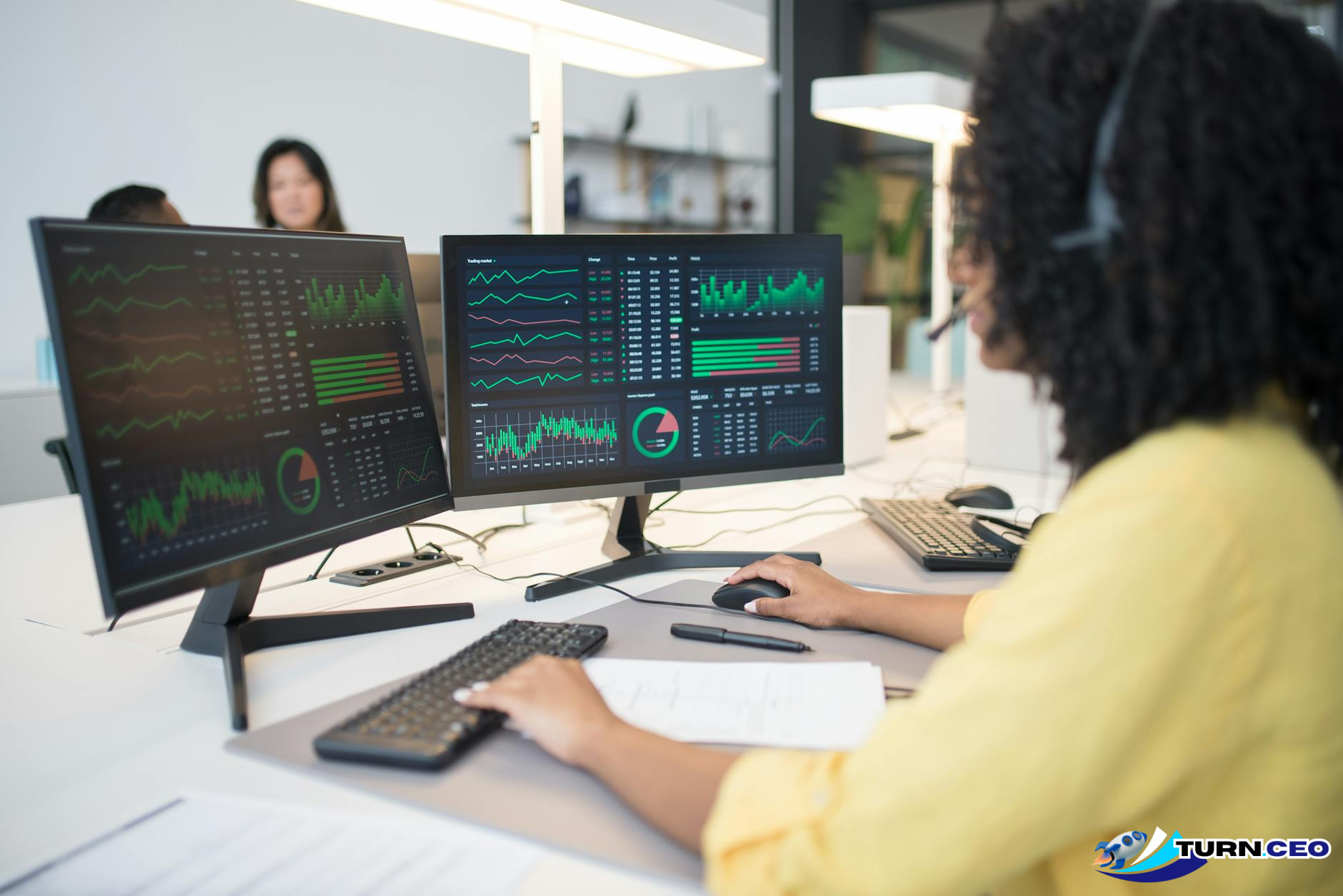 professional office setting with financial charts and data on computer screens