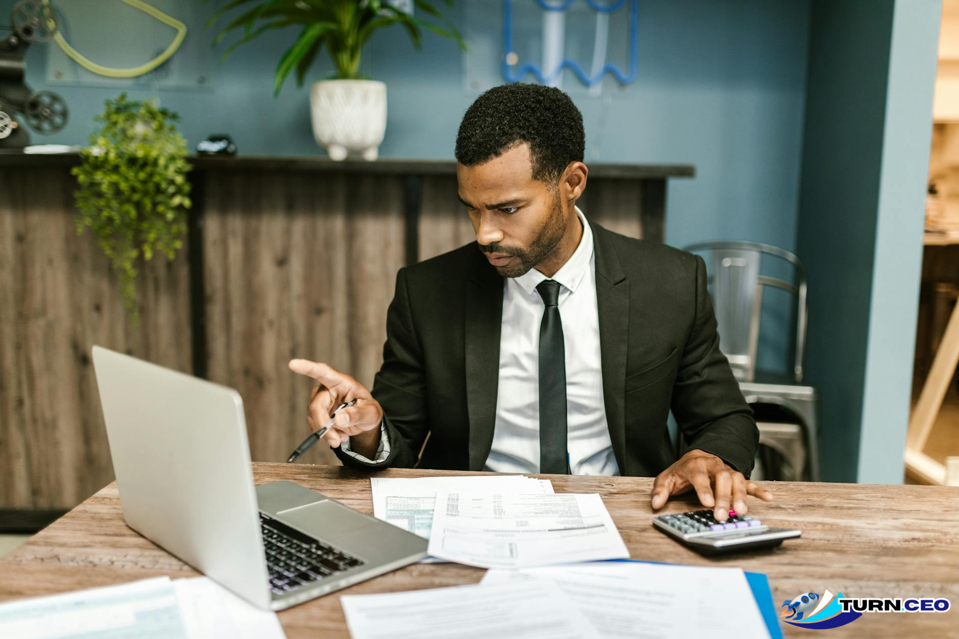 business owner looking at financial documents and calculator on desk