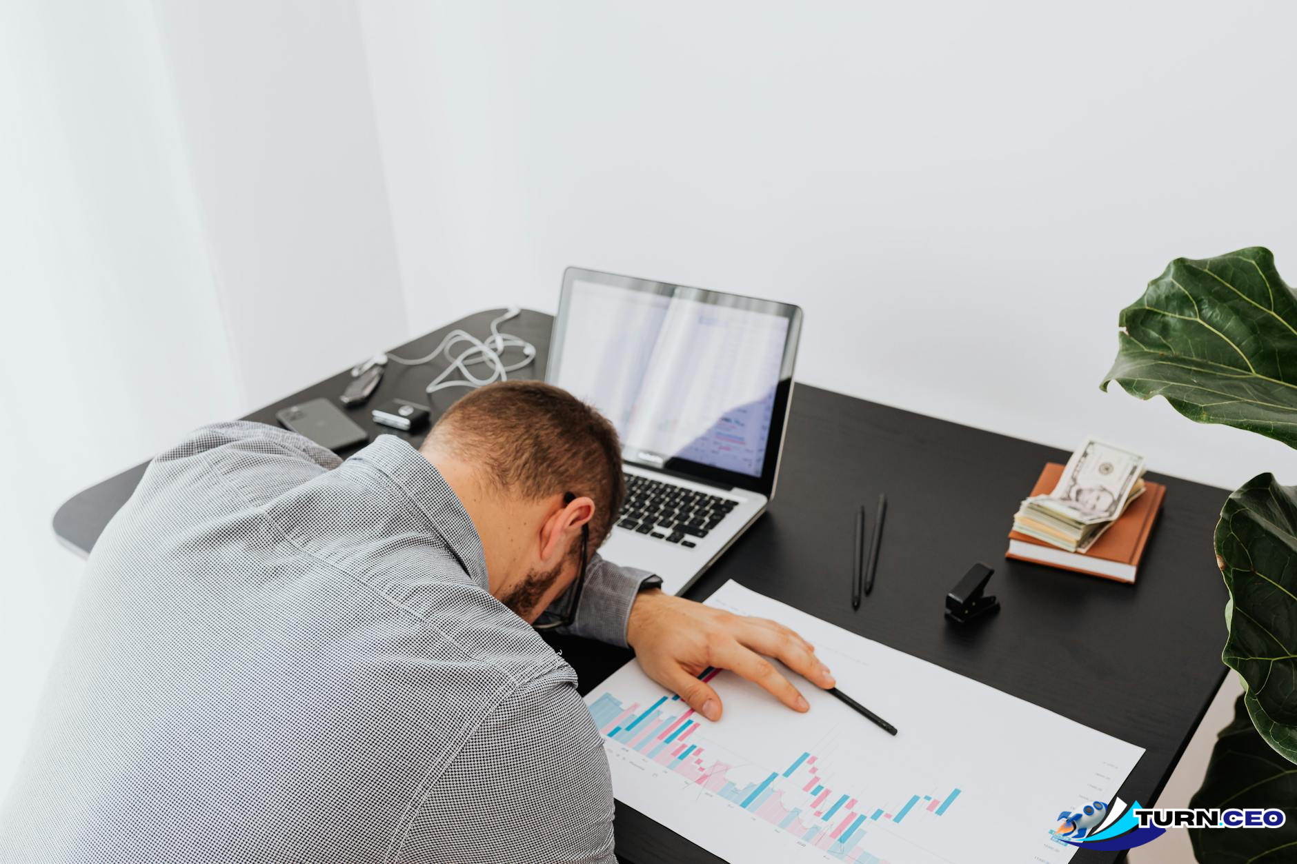 frustrated business owner looking at financial charts on laptop