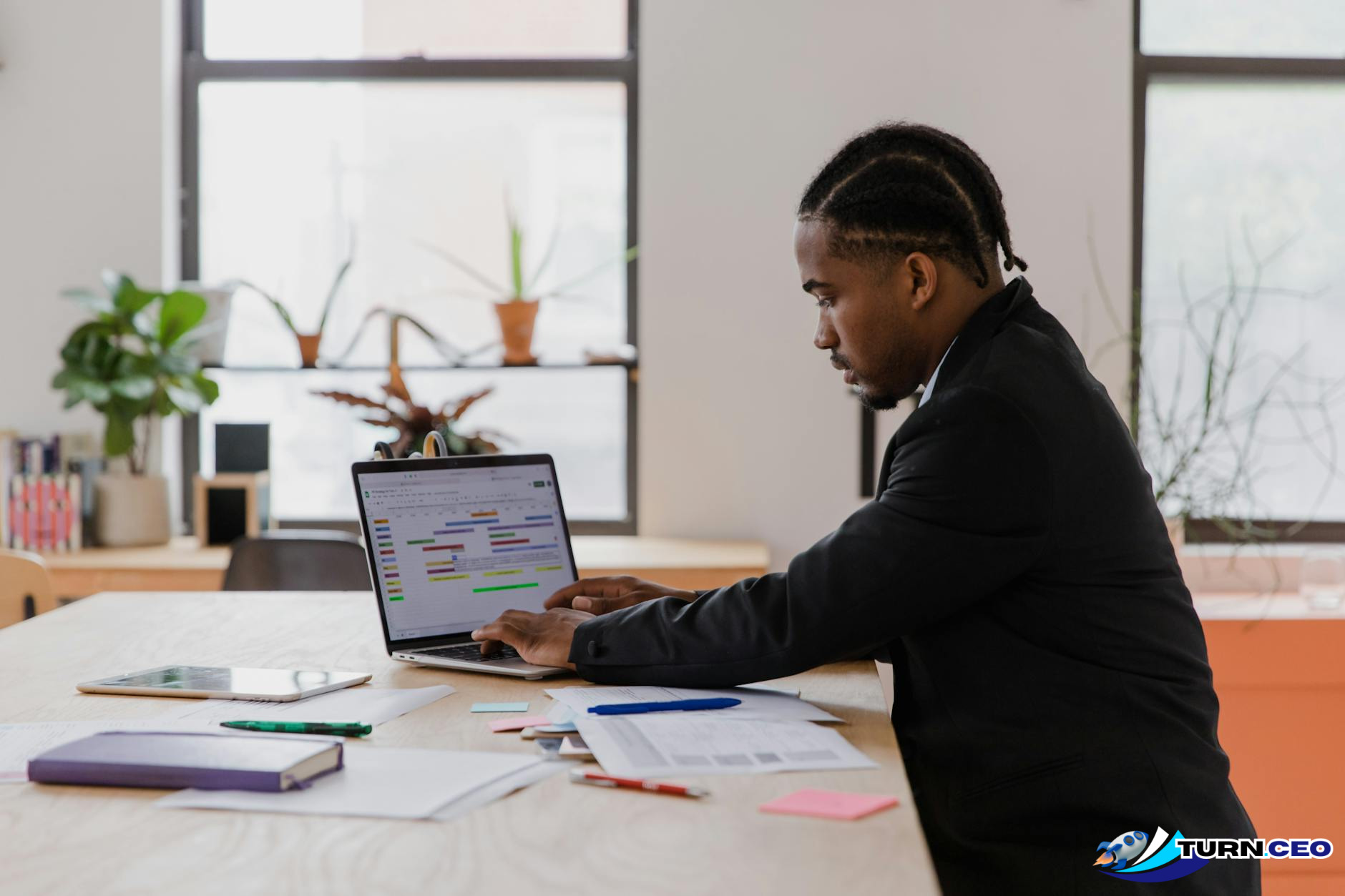 business owner working alone at desk with laptop and papers