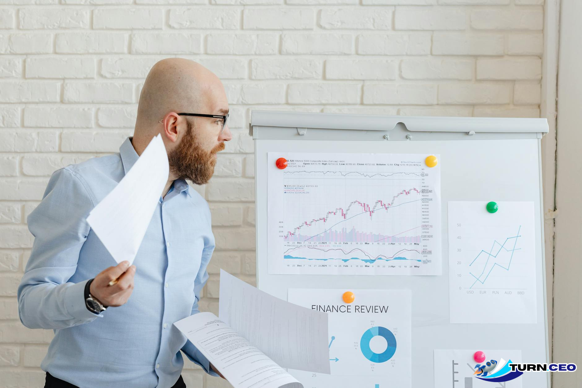 business owner reviewing financial charts and growth metrics at a whiteboard